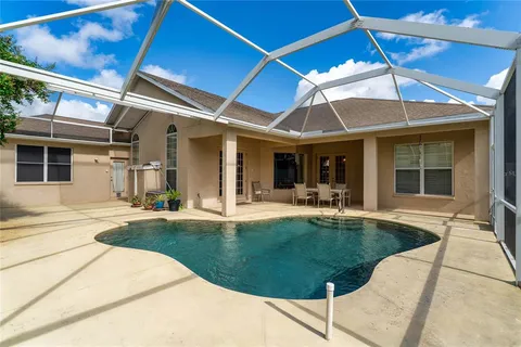 a swimming pool with outdoor seating and yard