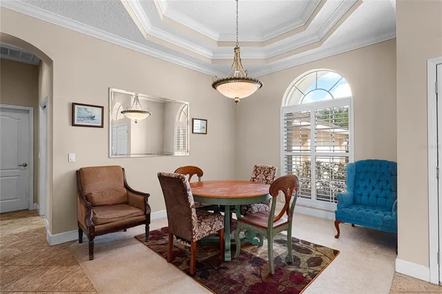 a dining room with furniture a chandelier and window