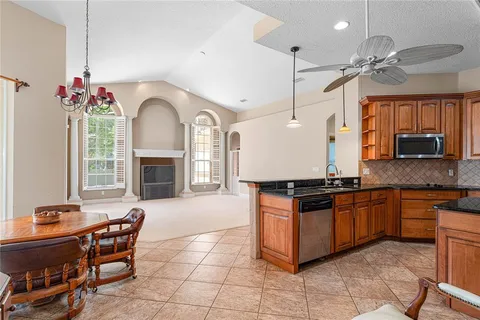 a kitchen with granite countertop a stove a sink and a refrigerator