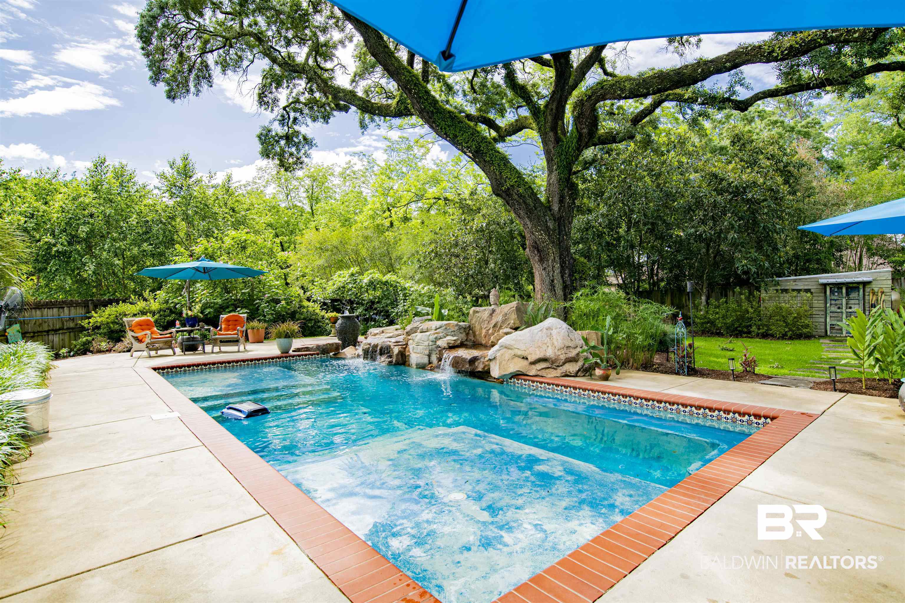 809 Bernard Circle Mobile, AL 36693 - Photo 62 of 75 Outdoor swimming pool featuring a built-in spa, rock waterfall feature, and surrounding concrete patio