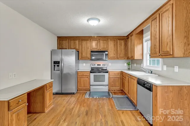 a kitchen with granite countertop a refrigerator stove top oven and sink