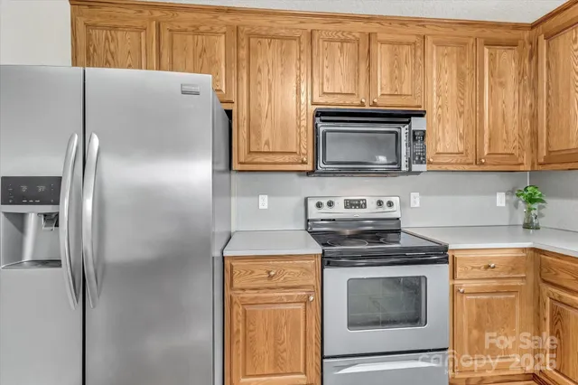 a kitchen with granite countertop a stove microwave and refrigerator