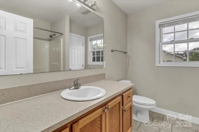 a bathroom with a sink toilet a mirror and a window