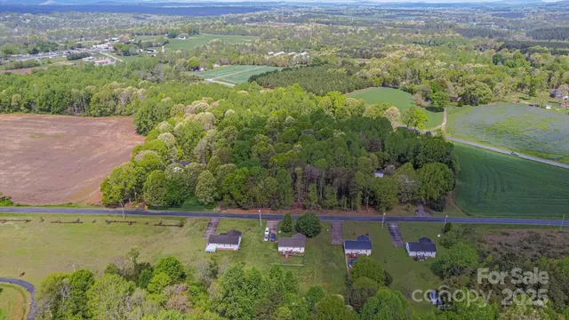 an aerial view of residential houses with outdoor space and trees