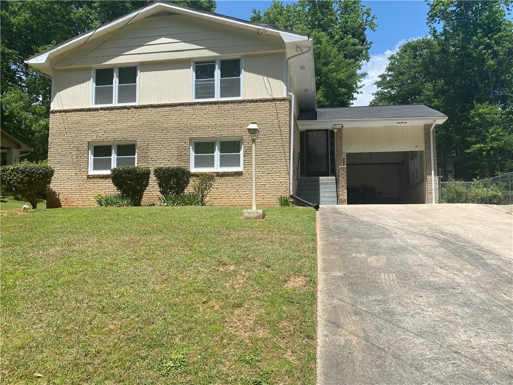 4065 Bakers Ferry Road Southwest Atlanta, GA 30331 - Photo 1 of 1 a front view of a house with a yard and garage