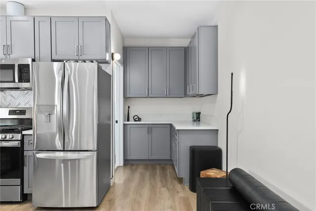 a kitchen with granite countertop a sink dishwasher stove and wooden cabinets