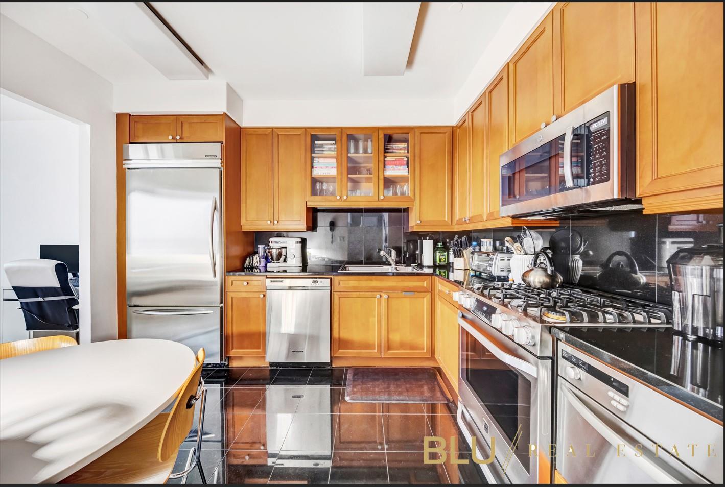220 Riverside Boulevard, Unit 15M Manhattan, NY 10069 - Photo 2 of 11 a kitchen with stainless steel appliances a stove a sink cabinets and a counter top space