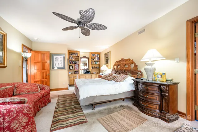 a spacious bedroom with a bed and a chandelier