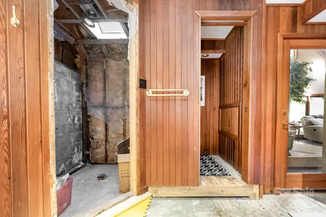 a view of a hallway with wooden floor and living room