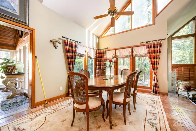 a dining room with furniture and large windows
