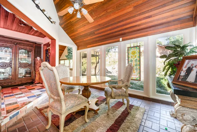 a dining room with furniture and large windows