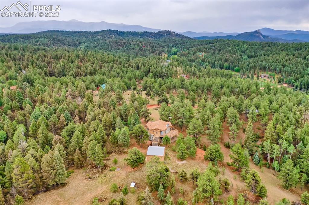 247 Pinewood Road Florissant, CO 80816 - Photo 35 of 39 a view of a lush green hillside and a building in the background