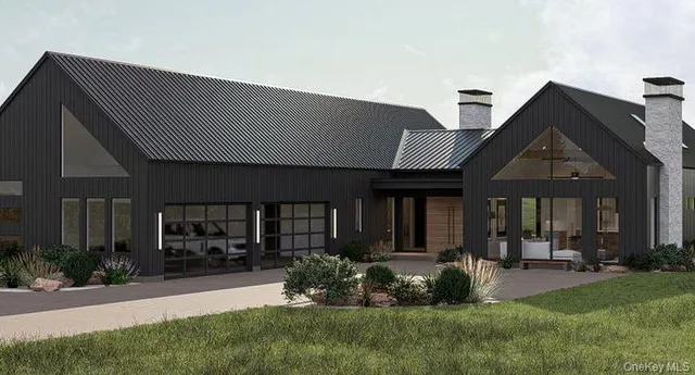 a front view of a house with a yard and potted plants