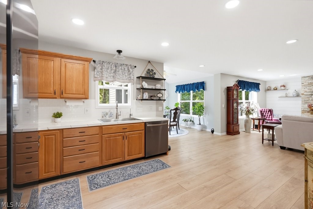 851 Susan Road Ravenna, OH 44266 - Photo 19 of 50 Light wood-finish flooring throughout, recessed ceiling lighting, natural wood cabinetry, stainless steel dishwasher, and white tile backsplash