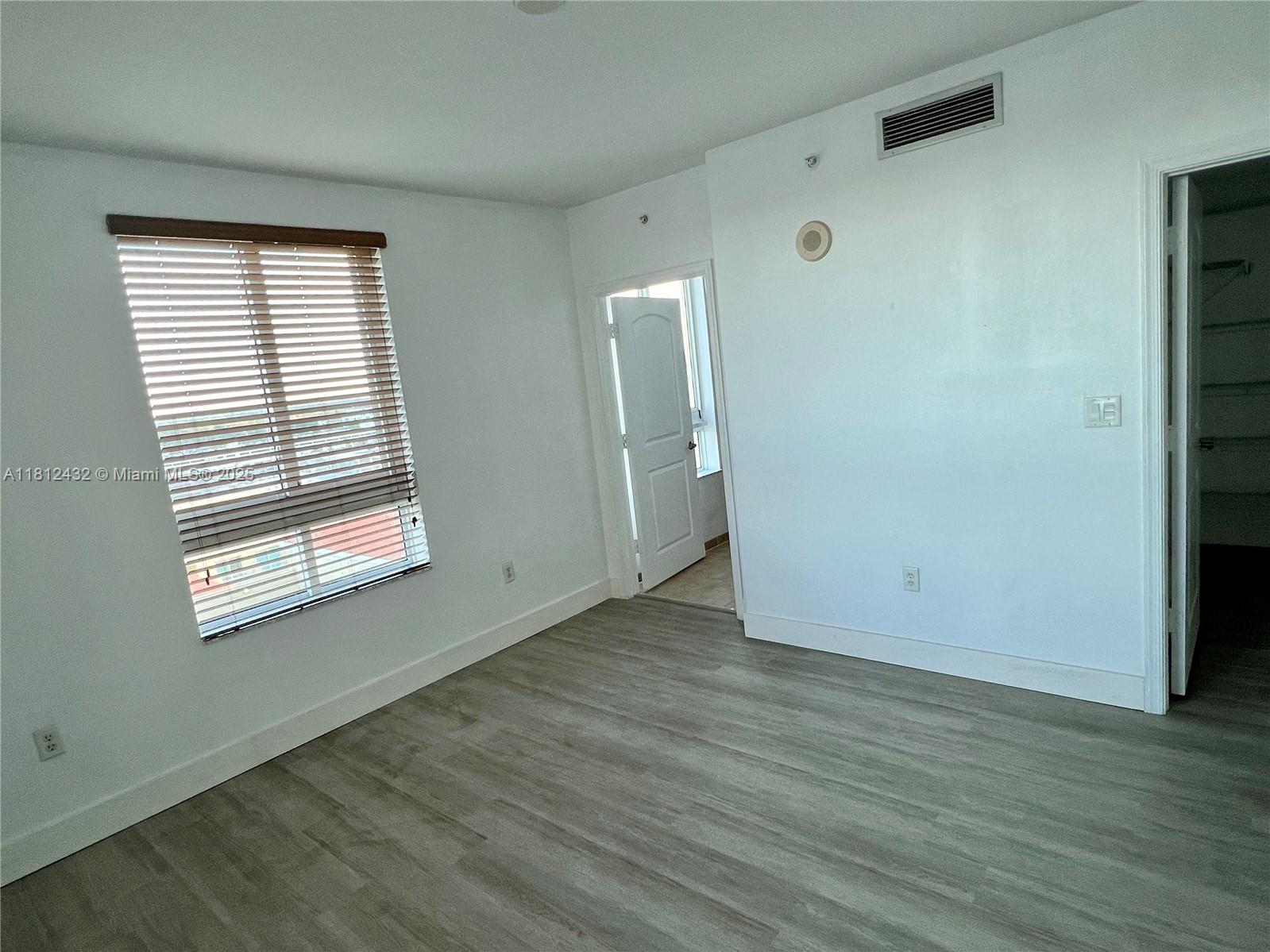 Kendall Miami, FL 33156 - Photo 16 of 22 an empty room with wooden floor and windows
