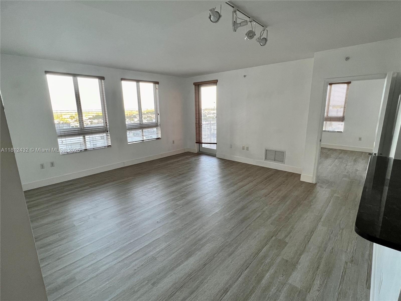 Kendall Miami, FL 33156 - Photo 8 of 22 an empty room with wooden floor and windows