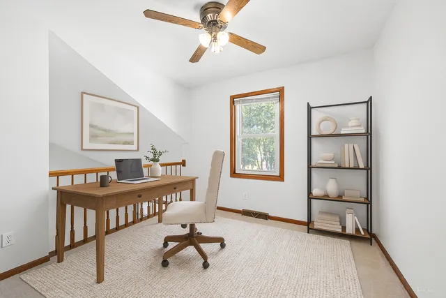 a view of a workspace with furniture and a window