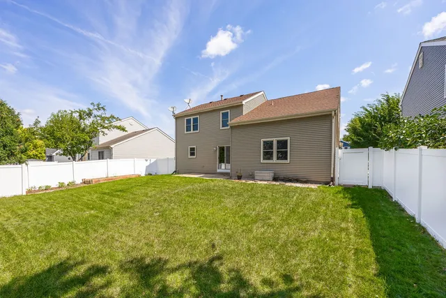 a backyard of a house with plants and a yard