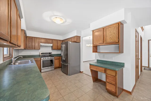a kitchen with stainless steel appliances granite countertop a refrigerator stove and sink