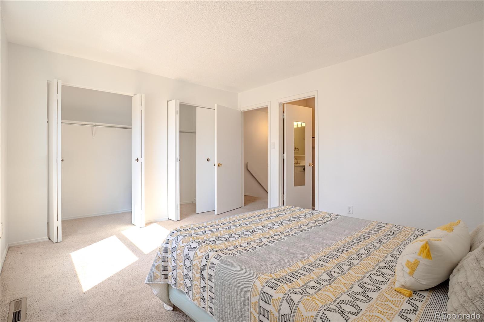 6315 Oak Street, Unit 2 Arvada, CO 80004 - Photo 15 of 34 a bedroom with a bed and a mirror