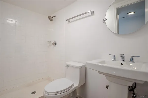 a kitchen with a refrigerator a sink dishwasher and white cabinets with wooden floor