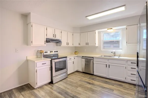 a kitchen with granite countertop white cabinets and white appliances