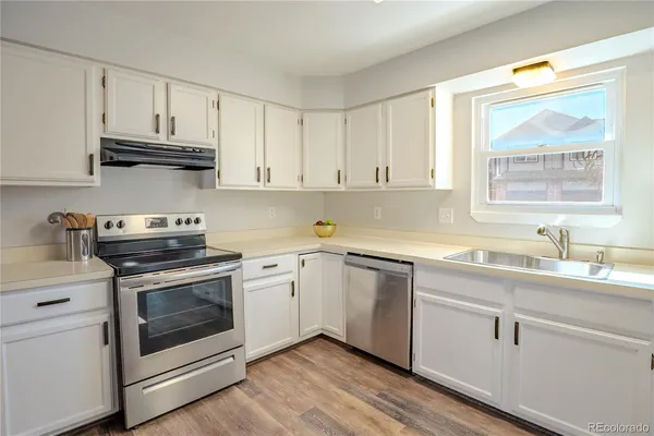 a kitchen with cabinets stainless steel appliances a sink and a window