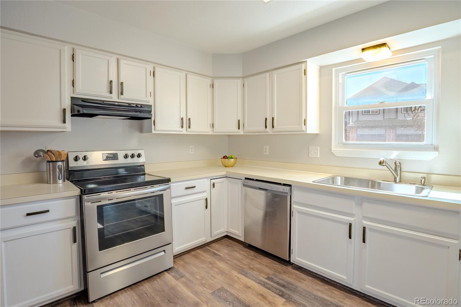 6315 Oak Street, Unit 2 Arvada, CO 80004 - Photo 10 of 34 a kitchen with cabinets stainless steel appliances a sink and a window