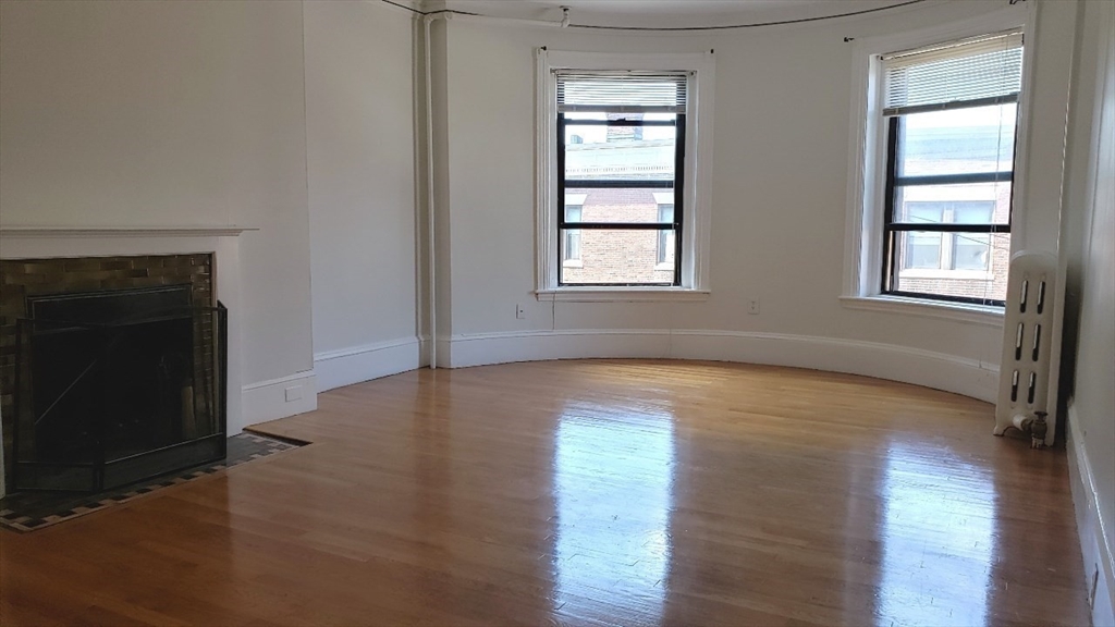 924 Beacon Street, Unit 6 Boston, MA 02215 - Photo 3 of 28 an empty room with wooden floor and windows