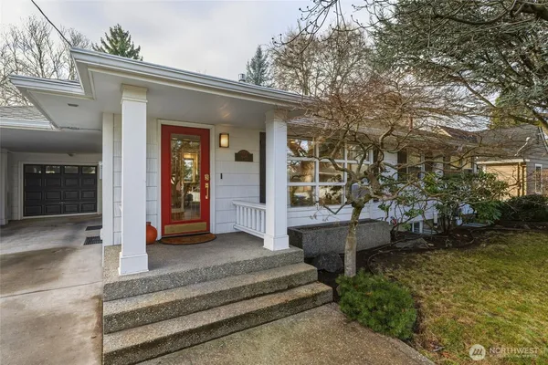 a view of a house with large trees and wooden fence