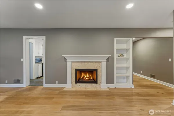 a view of an empty room with a window and wooden floor