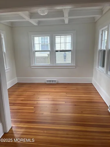 a view of a room with wooden floor and a window
