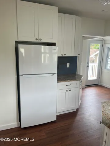 a view of a refrigerator in kitchen and wooden floor