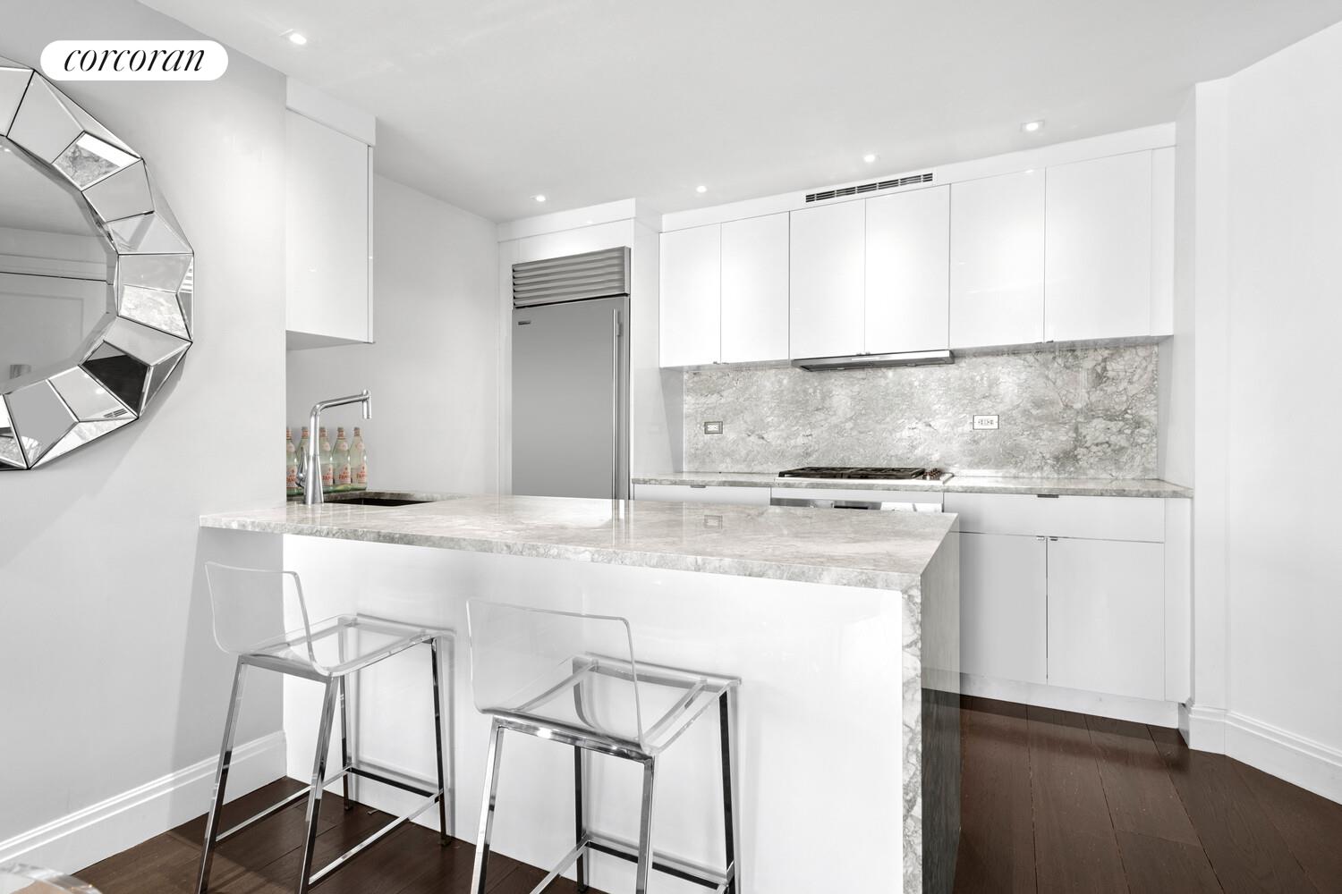 377 Rector Place, Unit 20B Manhattan, NY 10280 - Photo 3 of 10 a kitchen with a table chairs sink and cabinets