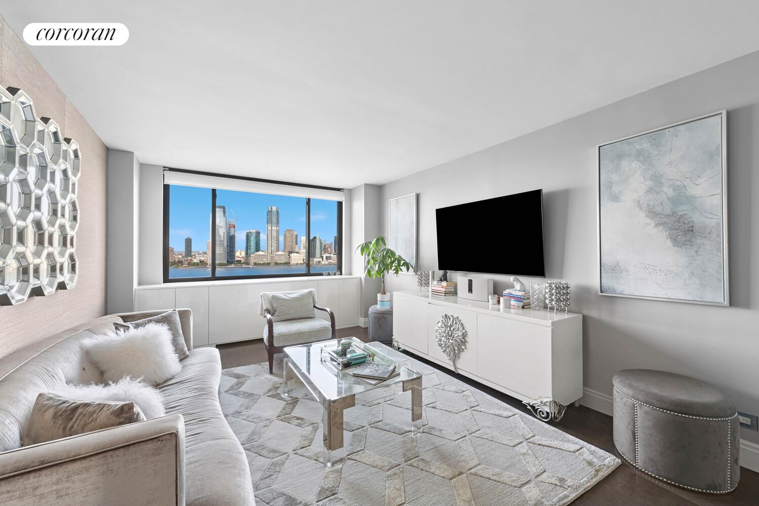 377 Rector Place, Unit 20B Manhattan, NY 10280 - Photo 4 of 10 a living room with furniture a flat screen tv and a floor to ceiling window