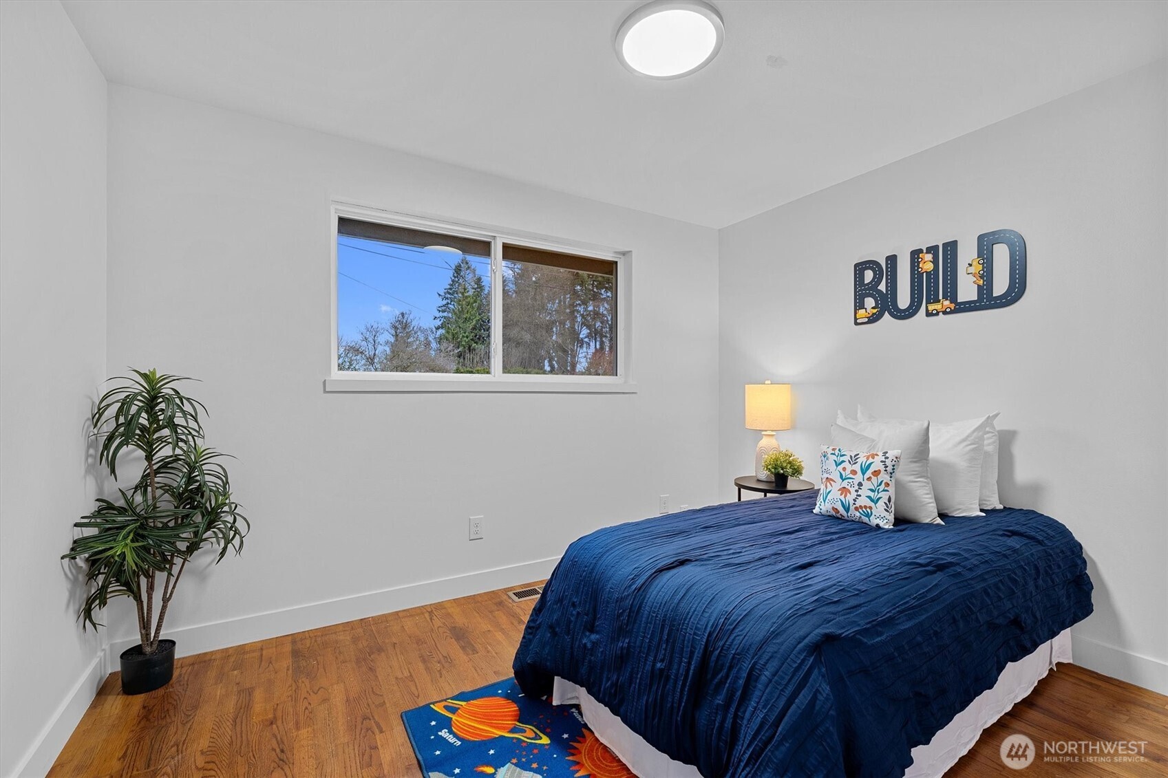 9218 Northeast 184th Place Bothell, WA 98011 - Photo 20 of 37 a bedroom with a bed and a wooden floor