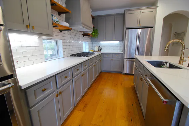 a kitchen with stainless steel appliances a sink stove and refrigerator