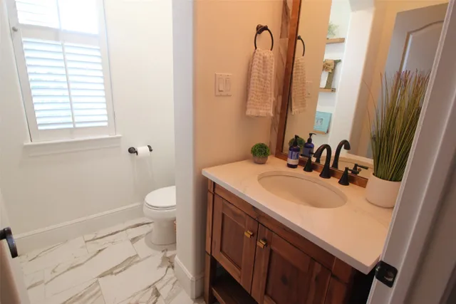 a bathroom with a sink a toilet and a mirror