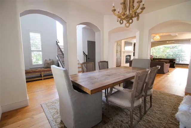 a dining room with furniture a chandelier and wooden floor