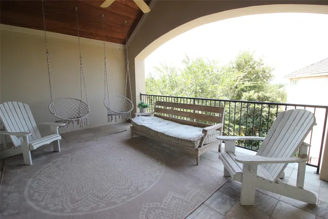 a balcony with wooden floor and outdoor seating