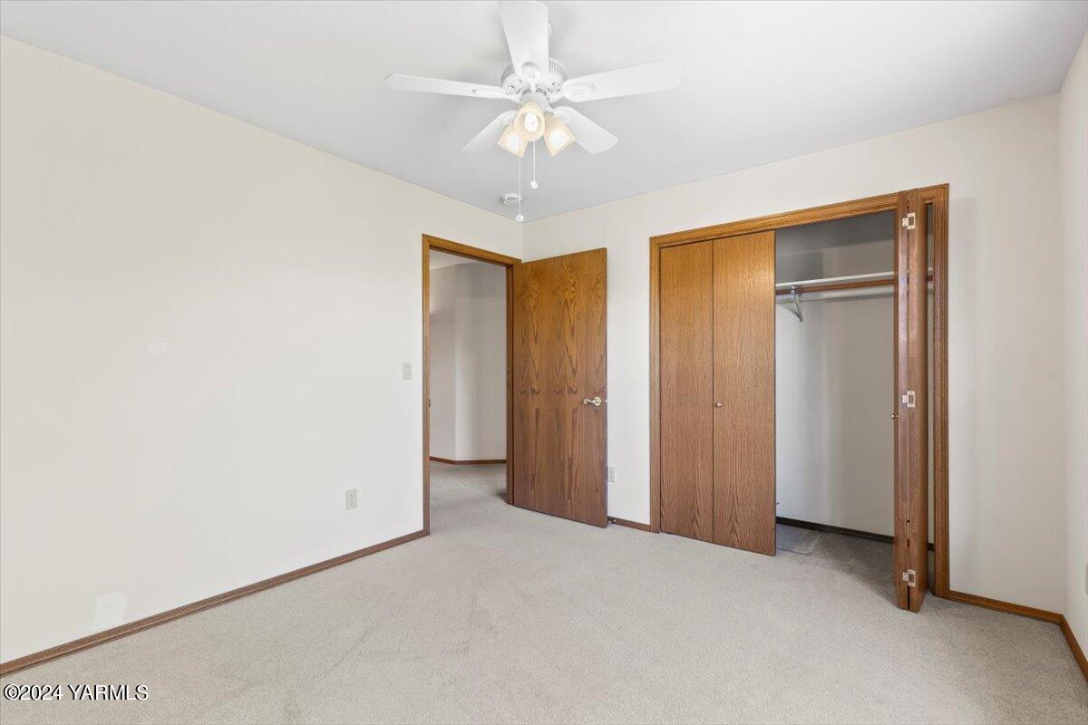 11810 West Barrett Road Yakima, WA 98908 - Photo 16 of 47 an empty room with a chandelier fan and closet area