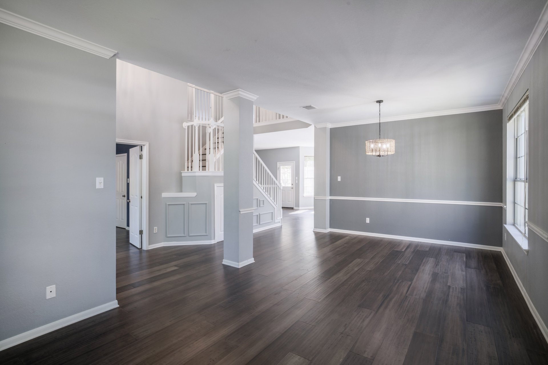 7113 Bending Oak Road Austin, TX 78749 - Photo 14 of 39 Rich dark wood floors and classic crown molding anchor this open dining and entryway space.