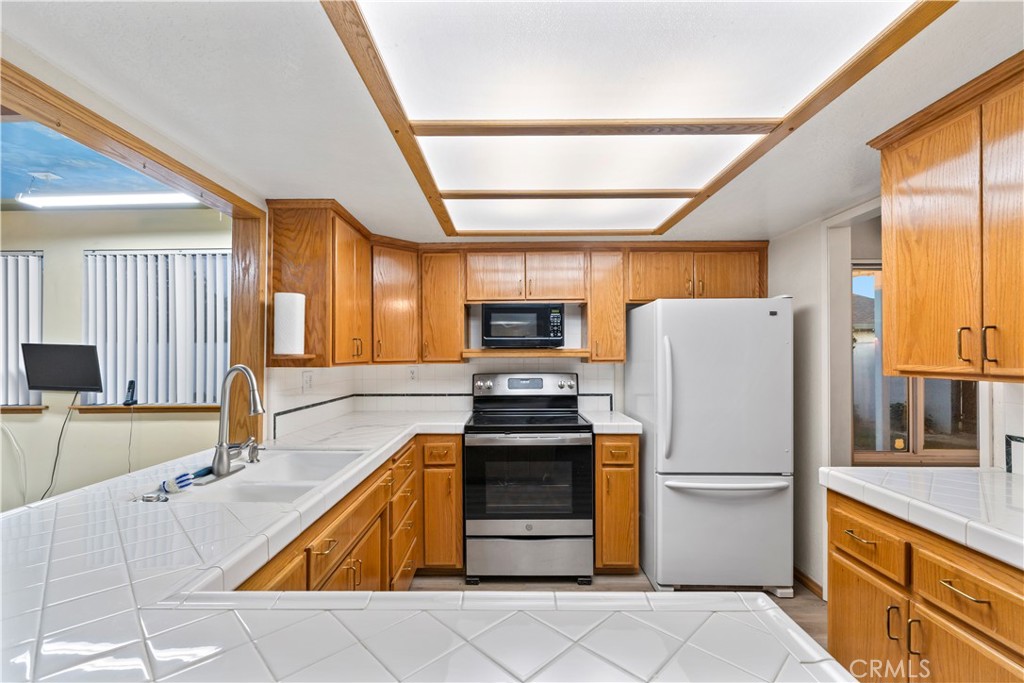 16464 Tullock Street Fontana, CA 92335 - Photo 11 of 43 a kitchen with stainless steel appliances a refrigerator and a stove top oven
