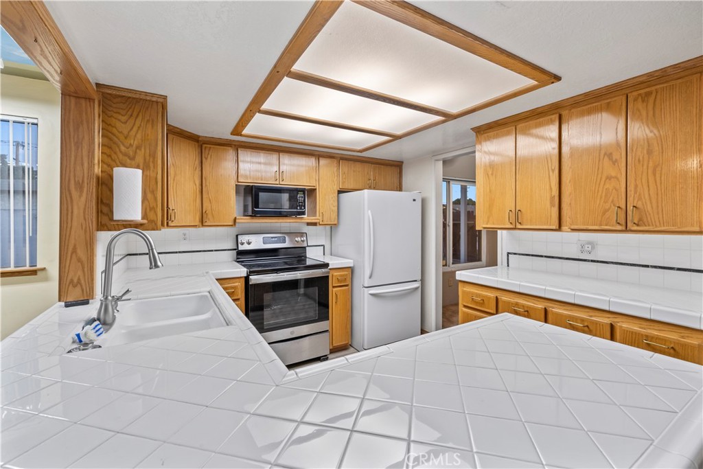 16464 Tullock Street Fontana, CA 92335 - Photo 12 of 43 a kitchen with stainless steel appliances a stove a refrigerator and a sink