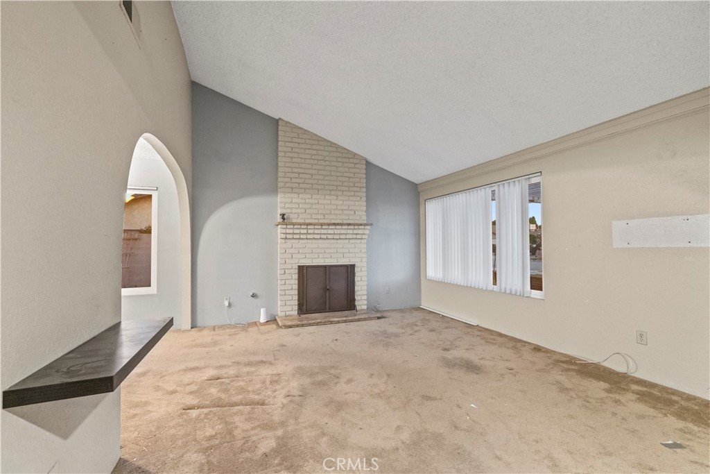 16464 Tullock Street Fontana, CA 92335 - Photo 3 of 43 a view of an empty room with a fireplace and a window