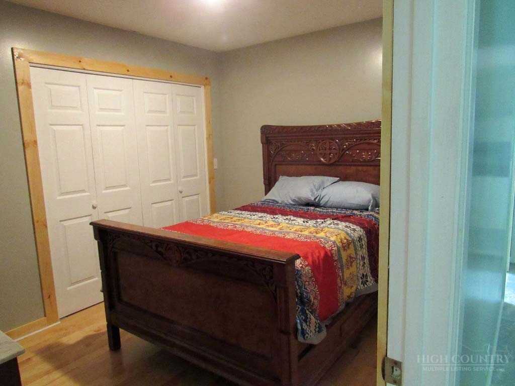 805 Ed Little Road Warrensville, NC 28693 - Photo 35 of 49 a bedroom with a bed and a mirror