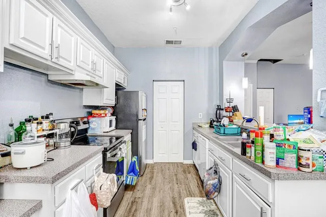 a kitchen filled with a white stove top oven and a refrigerator