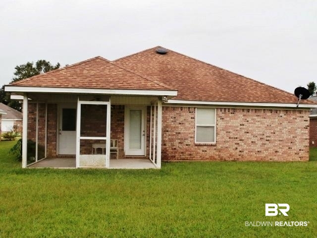 16976 Sugar Loop Foley, AL 36535 - Photo 15 of 16 Rear view of house featuring a lawn and a patio