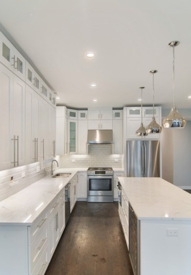 2448-50 North Clybourn Avenue Chicago, IL 60614 - Photo 6 of 10 a large white kitchen with a stove top oven a sink dishwasher and a refrigerator with wooden floor