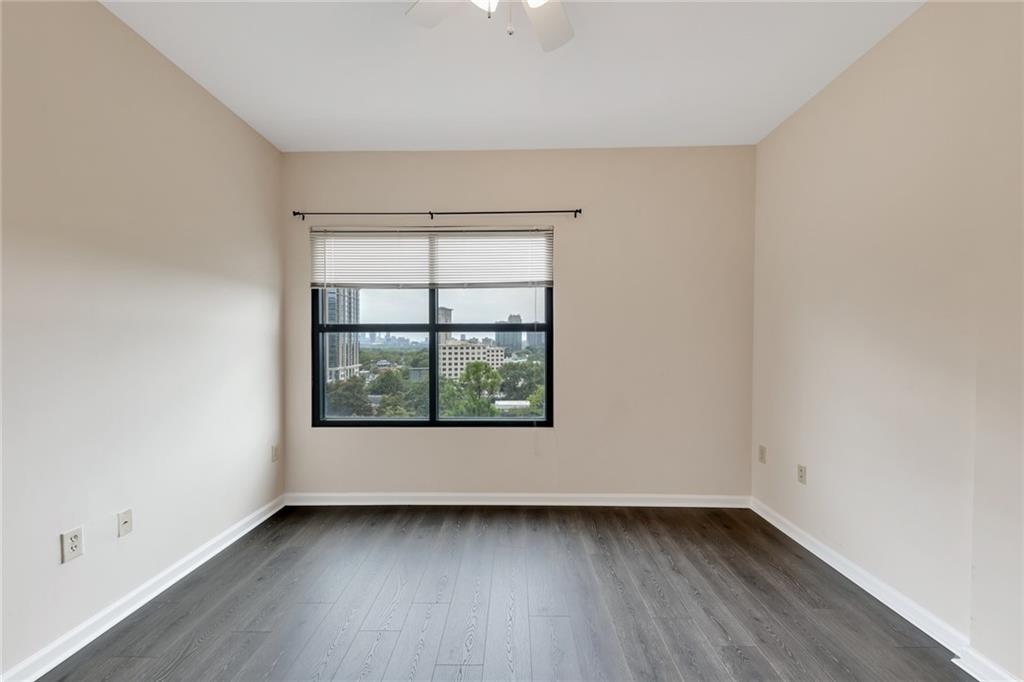 3040 Peachtree Road Northwest, Unit 704 Atlanta, GA 30305 - Photo 7 of 16 an empty room with wooden floor and windows